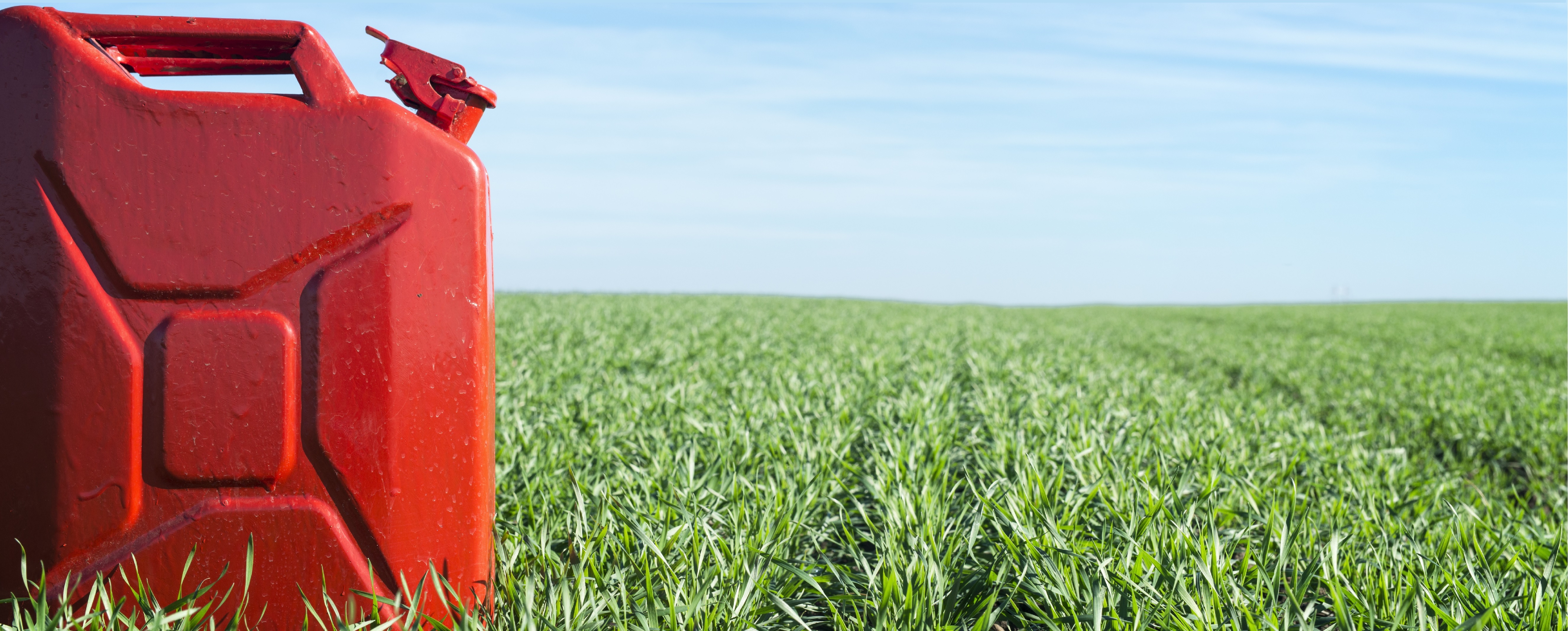 A red fuel tank on green grass to represent renewable fuel and renewable energy